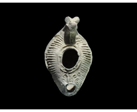 1st century BC-1st century AD. A small terracotta slipper-shaped oil lamp with radiating strokes to the upper face, nozzle wi
