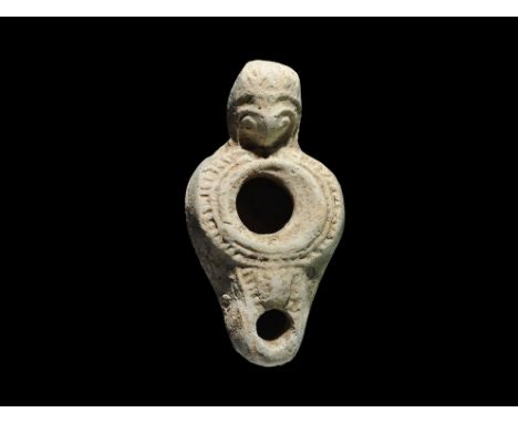 1st century BC-1st century AD. A small terracotta oil lamp with broad discus, pellets to the upper face, short D-shaped nozzl