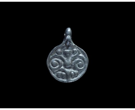 9th-12th century AD. A flat-section bronze discoid Scandinavian type pendant with integral loop, palmette motif with pellets.