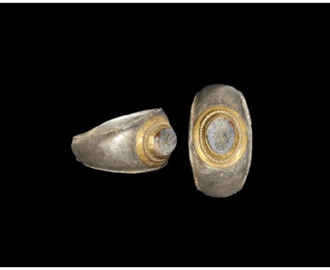 1st-2nd century AD. A D-section silver parcel-gilt hoop with slightly flared edges, discoid cell with beaded wire border, ins