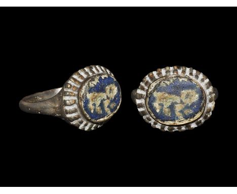 12th-14th century AD. A D-section silver hoop with vertically ribbed shoulders, discoid bezel with radiating bars to the oute