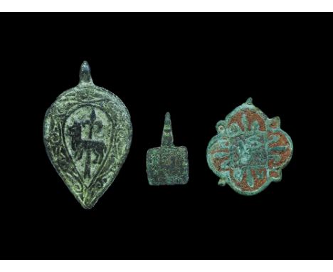 13th-15th century AD. A mixed group of bronzes comprising: a quatrefoil pendant with lobes between the leaves, central square