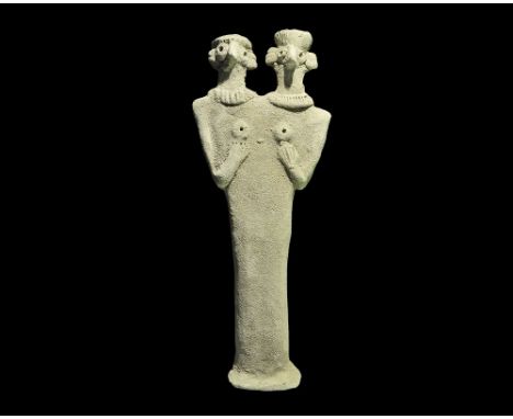 Syro-Hittite States, 1180-700 BC. A flat-backed ceramic figurine depicting a female with two heads; the eyes and breasts dome