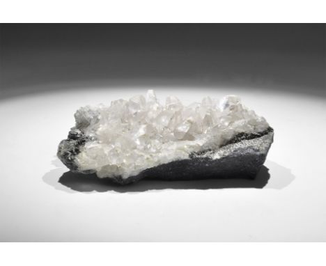 . A sheet of white to transparent calcite crystals on calcareous limestone exhibiting scalenohedral form, in old white card t
