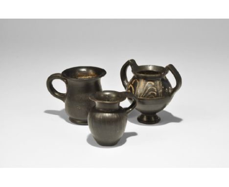 4th century BC. A mixed group of ceramic vessels comprising: a jug with flared rim, flared base and loop handle; a jug with f