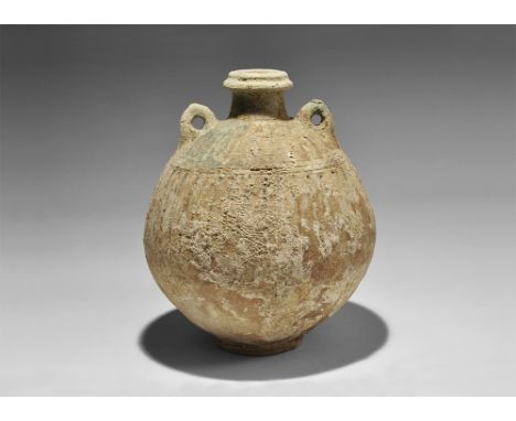 1st millennium BC. A globular ceramic jar with vertical rib detailing, narrow neck with collar, two loop handles to the shoul