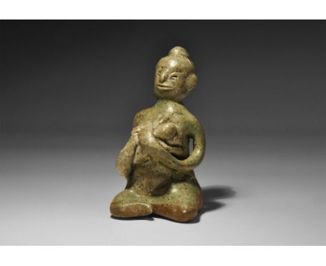 14th-16th century AD. A green-glazed ceramic figurine of a nude seated female suckling a baby; hollow to the underside. Cf. R