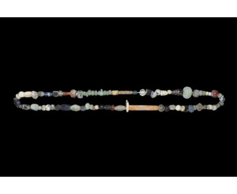 1st millennium BC. A restrung necklace of beads including tubular, globular, oblate and biconical profiles in glazed composit