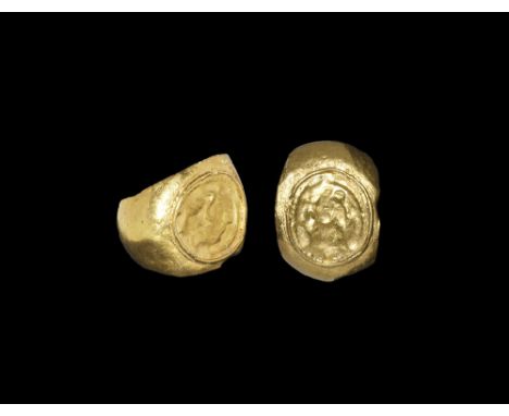 2nd-3rd century AD. A broad barrel-section hollow hoop with expanding shoulders, discoid plaque with raised rim and repoussé 