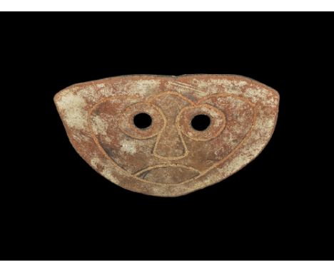 4th-3rd century BC. A D-shaped slightly curved ceramic mask with two eye-holes and incised stylised facial details. See discu