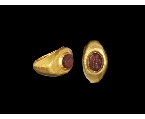 2nd-3rd century AD. A D-section hollow gold hoop with broad shoulders, elliptical plaque with discoid cell and inset glass cl