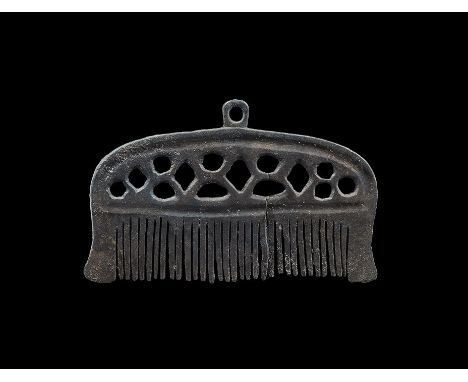 9th-12th century AD. A bronze single-sided comb with coarse-cut teeth, thickened border enclosing a panel of openwork lozenge