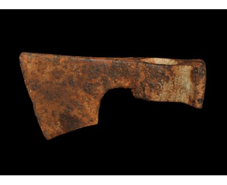 9th-12th century AD. A hand-forged iron axehead with circular socket and flat plaque to the rear, triangular-section blade wi