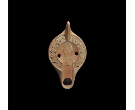 4th century AD. A slipper-shaped ceramic oil lamp with basal ring and concentric rings to the underside, broad nozzle and lug