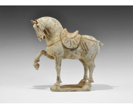 Tang Dynasty, 618-906 AD. A ceramic horse one a pentagonal base, in advancing pose with one foreleg raised, head tilted and m