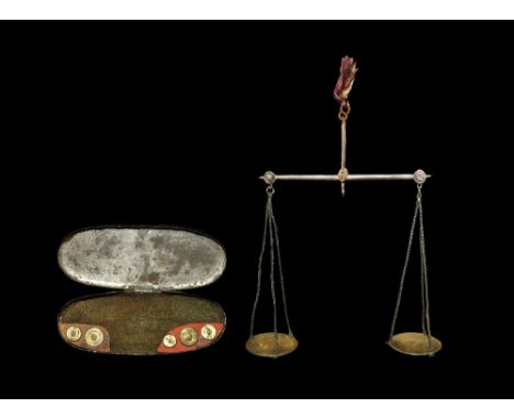 1816-1822 AD. A pair of coin weighing scales with brass pans, green cords and steel beam with red silk suspender, including m