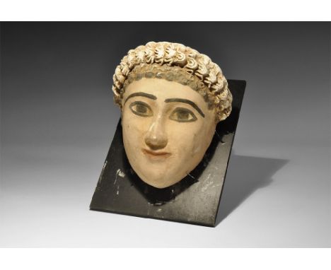 Romano-Egyptian Period, 30 BC-323 AD. A ceramic female mask with finely modelled facial features and elaborate hairstyle, bla