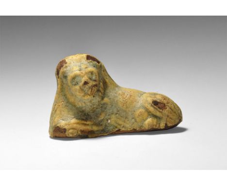 Ptolemaic Period, 332-30 BC. A blue-glazed ceramic statuette of a lion couchant with head turned to one side.    18 grams, 48