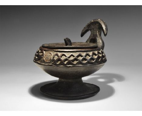 1st millennium AD. A ceramic carinated bowl with flared foot, bifid handle to the rear conjoined into a D-shaped plaque; runn