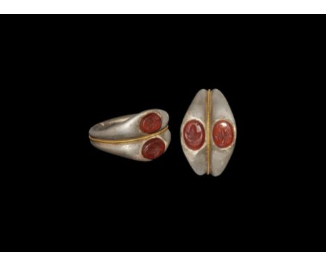 3rd century AD. A silver hoop of two round-section bands, gussetted with a gold filigree fillet to the centre; the bezels wit