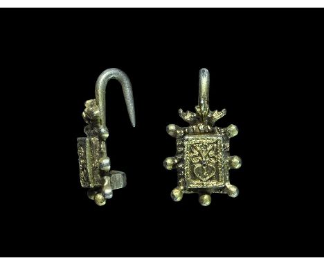 16th century AD. A silver-gilt dress fastener of Read's Class D Type 1 comprising a rectangular block with seven radiating lo
