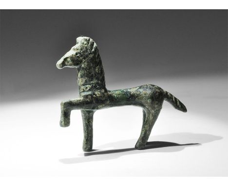 1st century BC-1st century AD. A bronze figurine of a horse with one foreleg raised, crimped mane, ring-and-dot eyes and coll