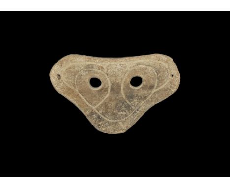 4th-3rd century BC. A heart-shaped slightly curved ceramic mask with two eye-holes and incised stylised facial details; pierc