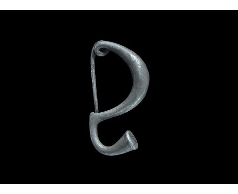 4th-3rd century BC. A silver fibula with deep round-section bow, looped spring and tapering pin resting on the integral catch