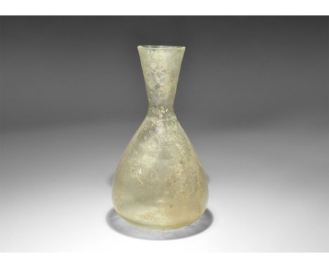 2nd-4th century AD. A bulbous green glass vessel with a conical body and broad funicular rim. Cf. Whitehouse, D. Roman Glass 
