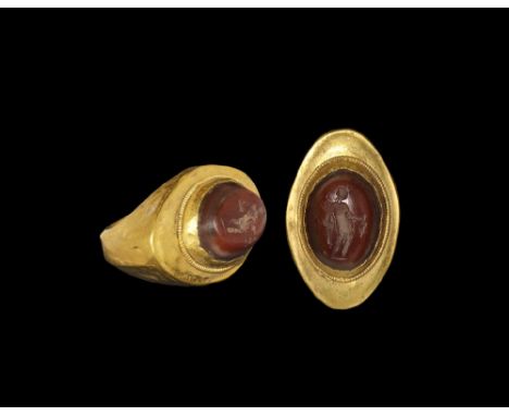 2nd-3rd century AD. A D-section hollow gold hoop, flat plaque with beaded wire rim to the central cell and inset banded agate