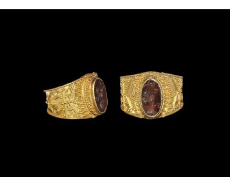 3rd century AD. A large broad flat-section gold hoop with applied filigree borders, bands of scroll and granule detailing; ce