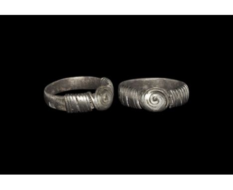 9th-11th century AD. A flat-section silver hoop with applied wire to both shoulders, coiled wire spiral forming the domed bez