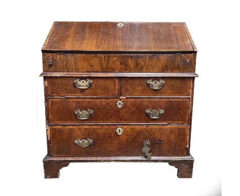An early 18th century walnut veneered bureau, the fall front opening to reveal a fitted interior with two short and two long 