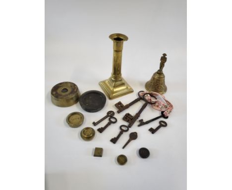 A collection of antique keys, a brass Napoleon bell, a brass candlestick and kitchen weight.