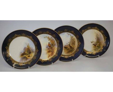 Four Royal Worcester plates signed Johnson, decorated with game birds within blue and gilt borders, date codes circa 1924, pr