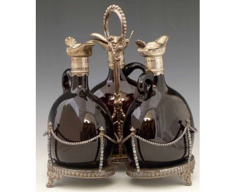 Victorian silver plated decanter stand of three brown glass decanters with hinged covers and stoppers, height 28cm.    Condit