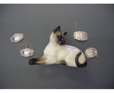 A Beswick pottery cat model number 1558, together with four silver decanter labels; Martini, Sherry, Gin and Port, two hallma