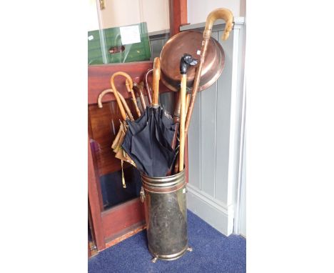 A BRASS UMBRELLA/STICK STAND inluding a collection of sticks and umbrellas and a 19th century copper bed-warming pan