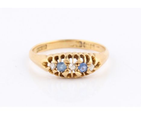 An early 20th Century 18ct yellow gold Edwardian style sapphire and diamond five stone ring, with three round cut diamonds in