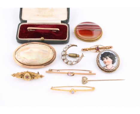 A collection of brooches to include a Victorian memorial brooch, hallmarked Birmingham 1898, a garnet bar brooch, a carved mo