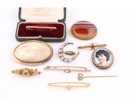 A collection of brooches to include a Victorian memorial brooch, hallmarked Birmingham 1898, a garnet bar brooch, a carved mo