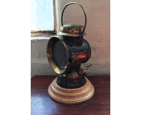 An early 20th Century Lucas 'King of the Road' car head lamp with later wooden plinth.