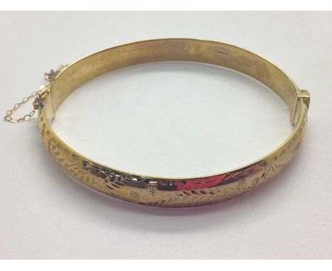A 9ct Gold Hollow Hinged Bangle, of etched foliage design, to push clasp and safety chain (damages) (8grams).