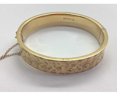 A Vintage 9ct Gold Hollow Hinged Bangle, of wide design with allover foliage decoration, to push clasp and safety chain (17gr