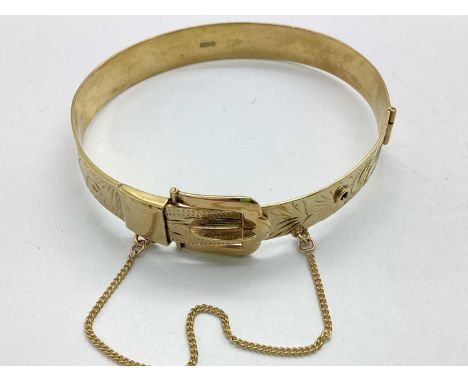 A 9ct Gold Vintage Hinged Buckle Bangle, E.J.Ld, the hinged front of scrolling foliage design, with applied buckle fastener a