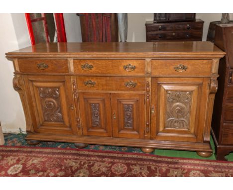 A Victorian carved light oak sideboard