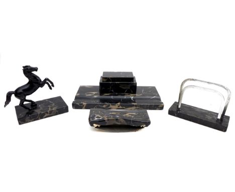 A set of black marble desk items, comprising an inkwell, 28cm across, a letter rack, a blotter, and a horse sculpture. (4) 