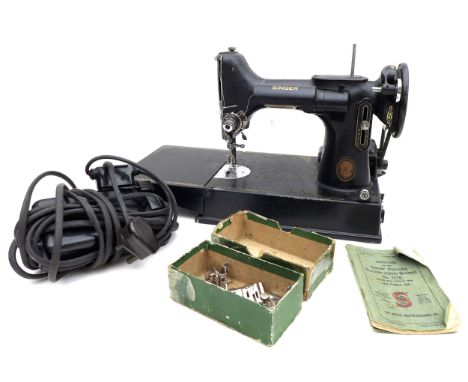A group of four sewing machines, comprising a vintage Singer Featherweight 221K1 portable electric sewing machine, serial EH8