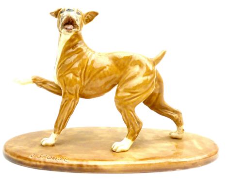 A ceramic figurine, with incised signature 'J Spouse', modelled as a brindle boxer dog in standing pose with right forepaw ra