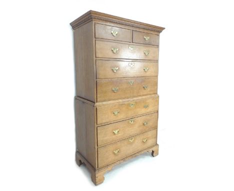 A mid 19th century oak tallboy, dentil moulded cornice above two short over six long graduating drawers, with cast brass hand